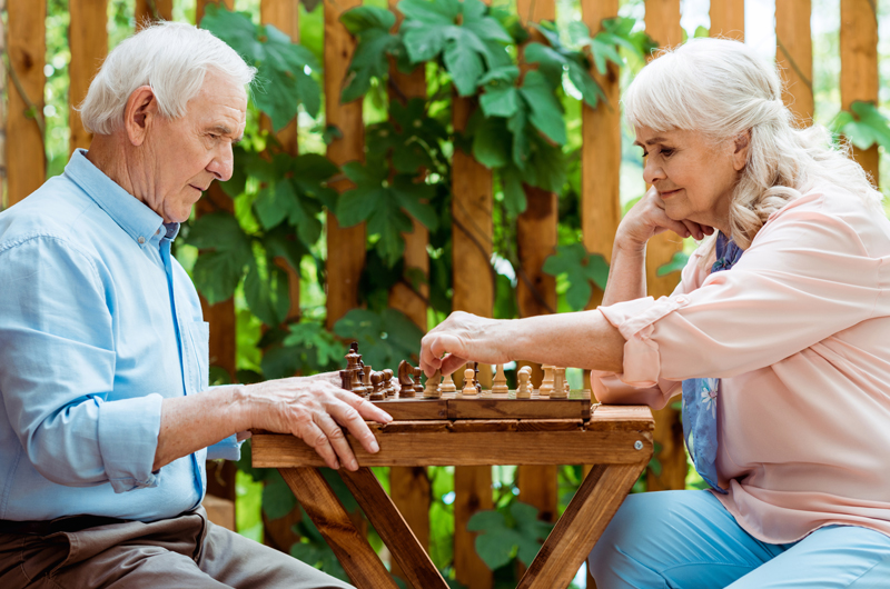 seniorzy ćwiczący pamięć grą w szachy